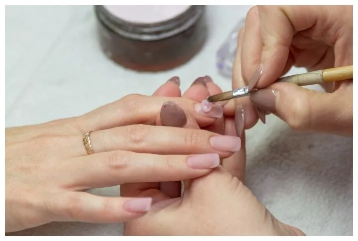 applying-a-brush-on-acrylic-nails-in-the-salon-by-Korvik.jpg